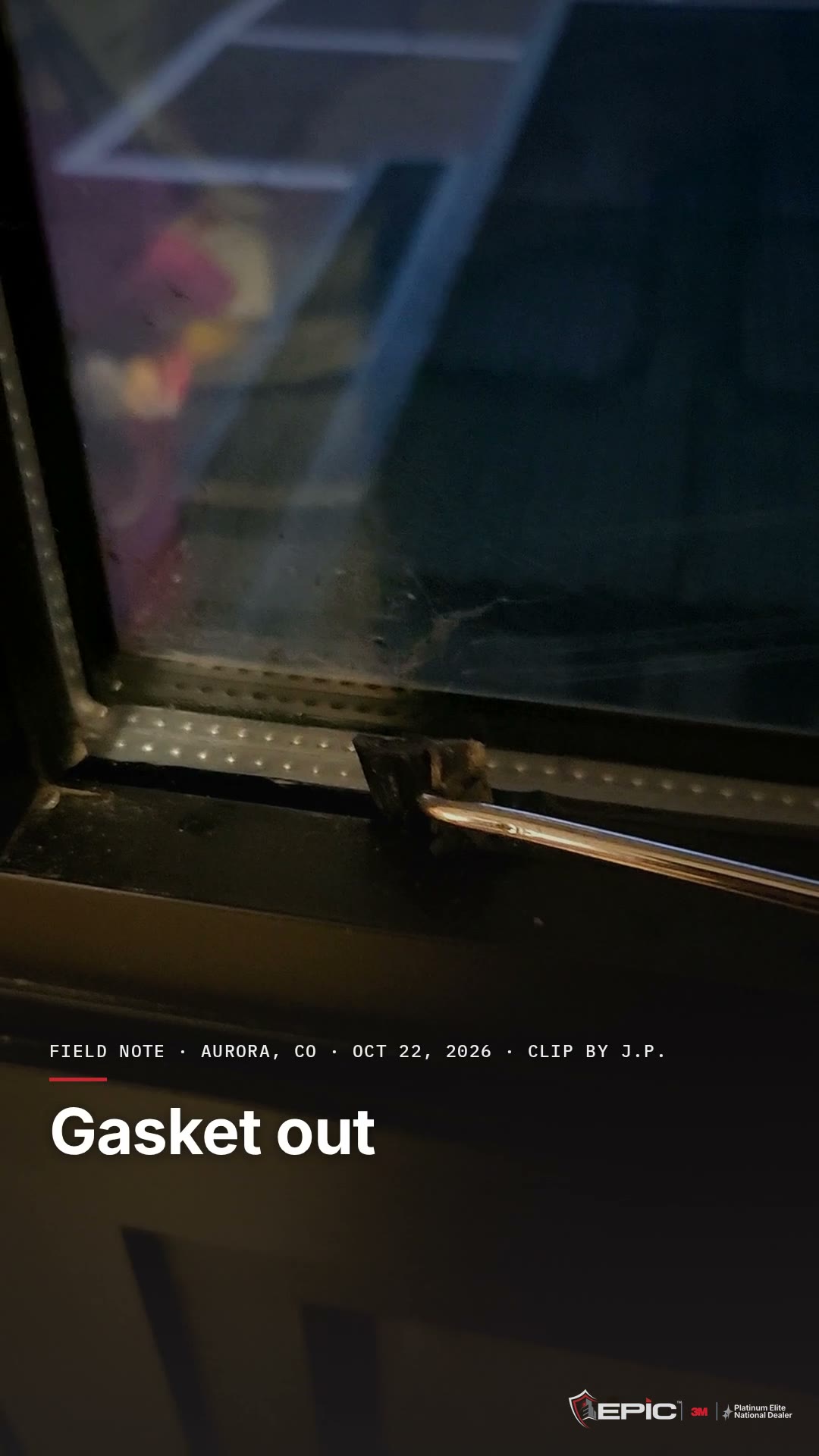 A pry tool lifting the rubber gasket out of a window frame at a Cherry Creek school before security film is installed