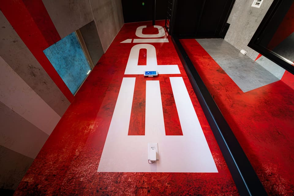 Corridor floor covered in a red and white graphic spelling EPIC, seen from above