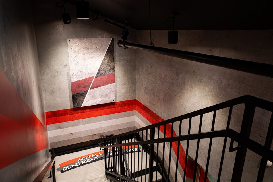 Stairwell with a graphic wall panel and a red stripe running down toward the landing