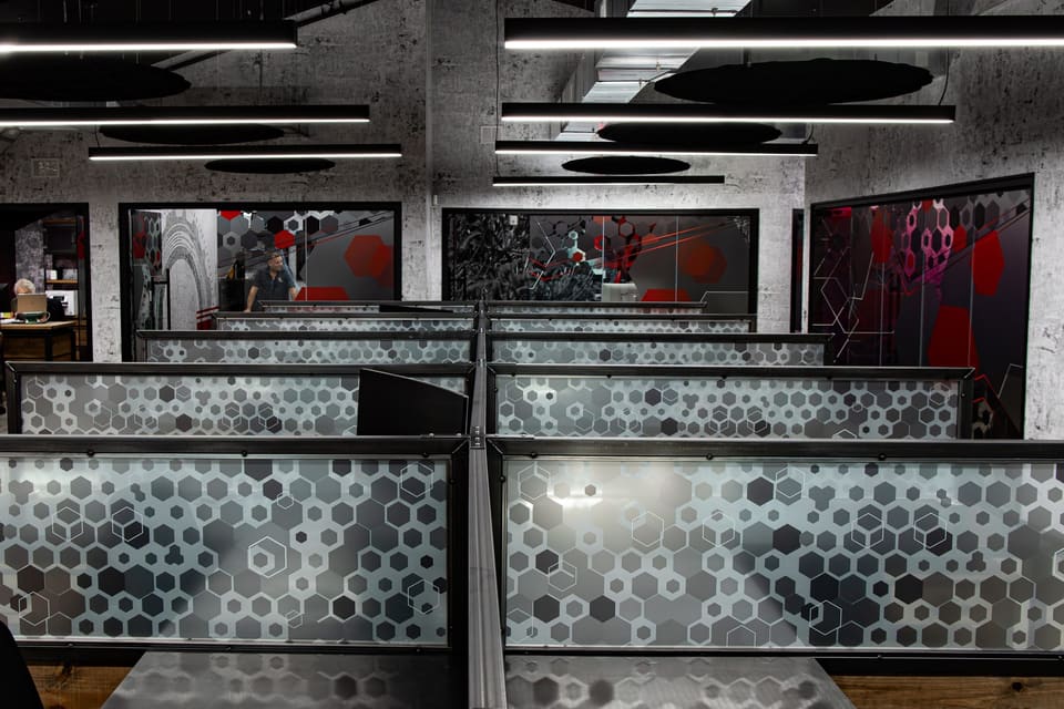 Close view of workstation partition panels covered in a gray gradient hexagon pattern
