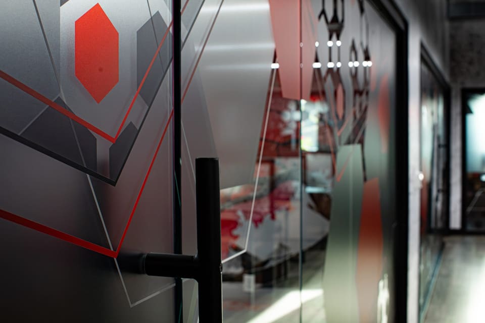 Glass door with frosted film, a red hexagon and fine red linework