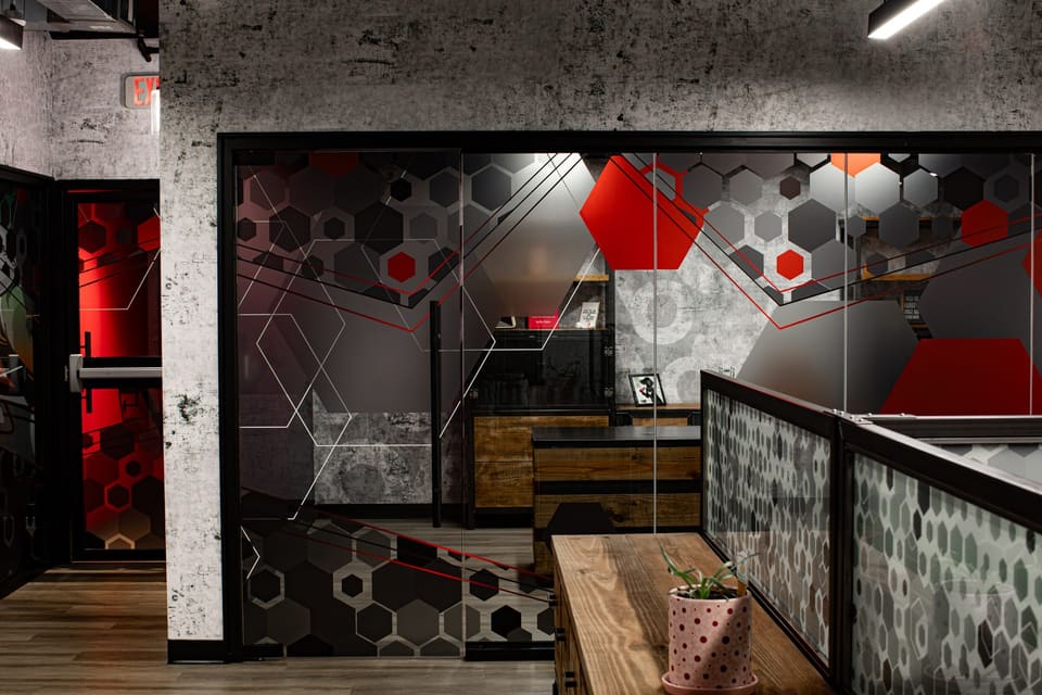 Glass office wall and railing panels with a matching gray and red hexagon film pattern