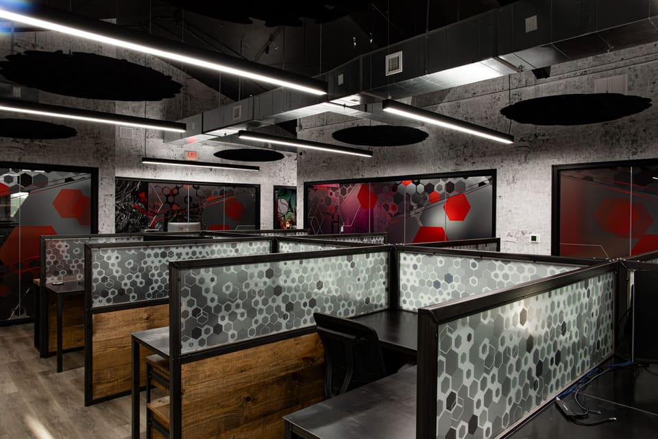 Workstation panels with hexagon pattern and colorful printed glass offices in the background