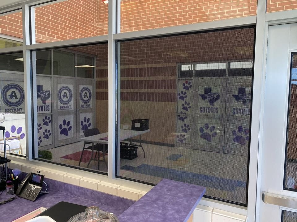 Anna ISD front office glass with purple paw prints, a Texas outline and the school crest printed on frosted film