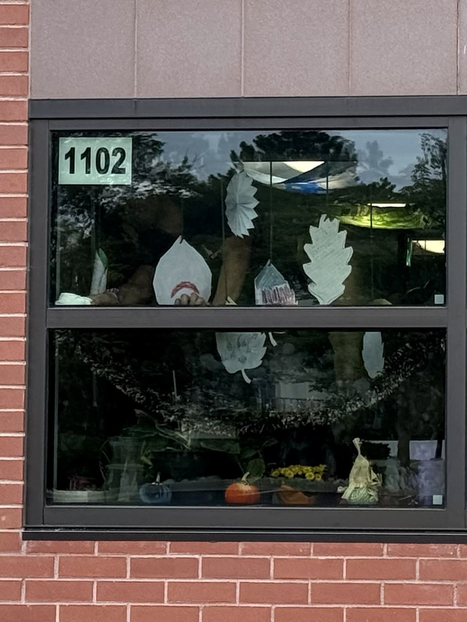 Classroom window 1102 with a double-sided room number on film-safe media over the security film