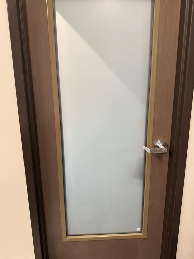 School office door with matte privacy film on the glass