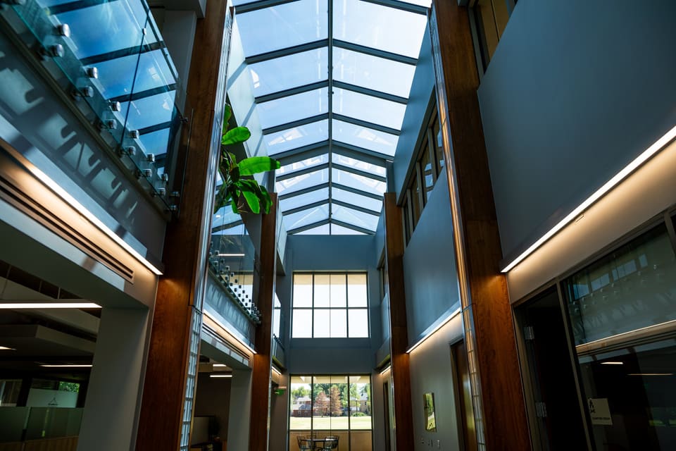 Interior atrium with timber columns and a glass skylight overhead