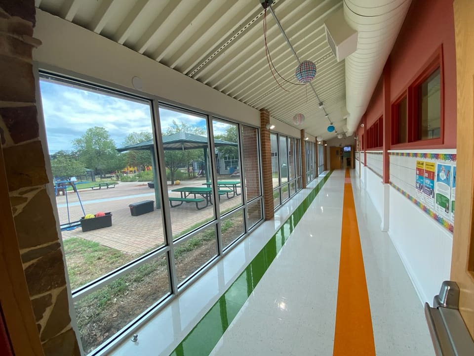 School corridor lined with floor-to-ceiling courtyard glass, filmed by Epic