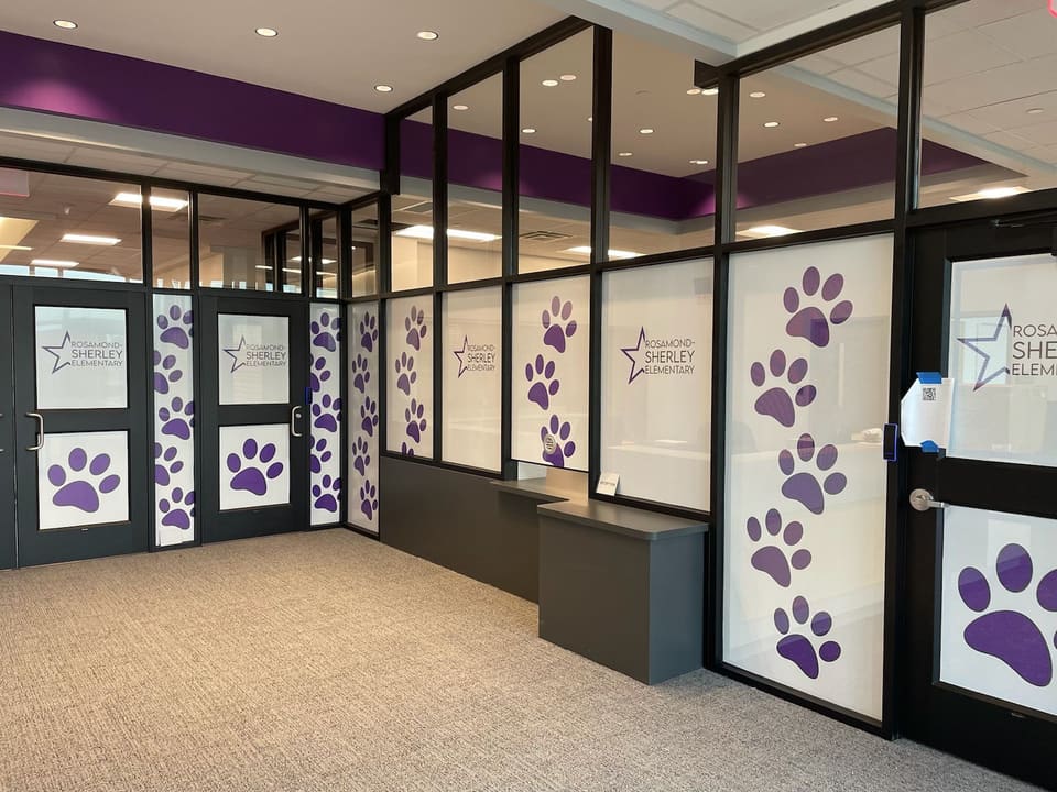 Elementary school secure vestibule with purple paw-print window graphics