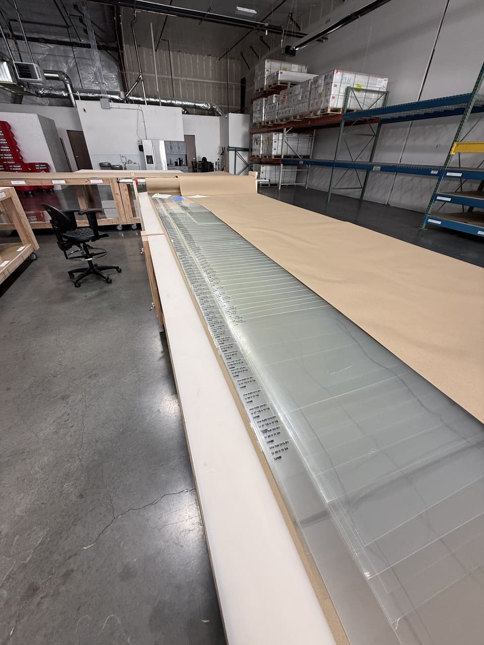 Epic’s precision cutting table in the Colorado cutting department with a roll of 3M security film loaded and a nested cut in progress