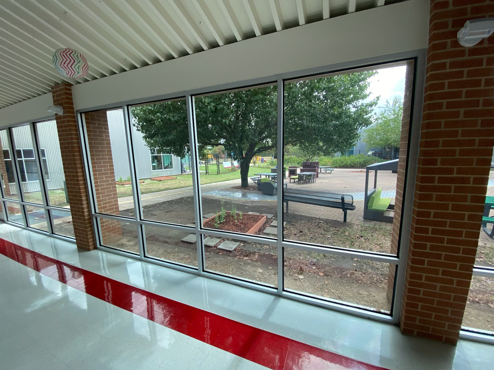 School commons with a wall of courtyard glass — the window film visualizer